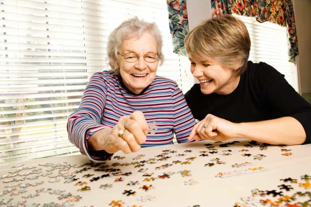 Two women young and old completing a puzzle